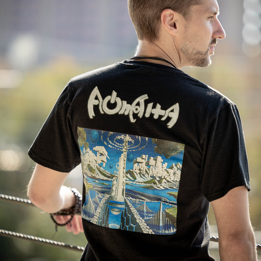 Man wearing a black t-shirt with a graphic design and text on the back, standing outdoors.